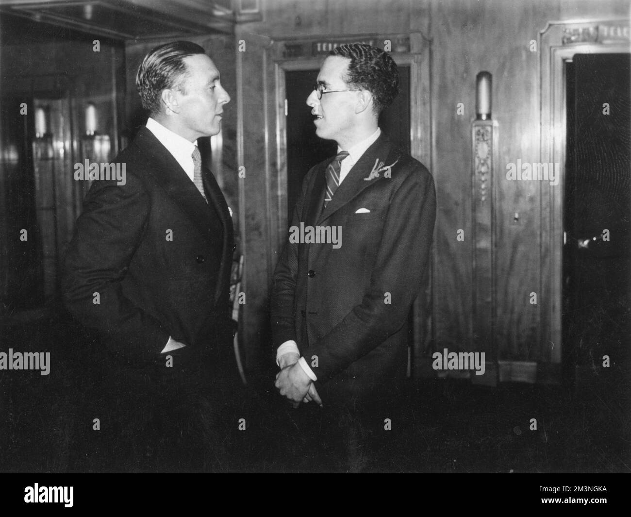 George O'Brien (1899 - 1985), American silent movie actor pictured in conversation with Victor Stiebel (1907 - 1976), British fashion designer.     Date: c.1935 Stock Photo