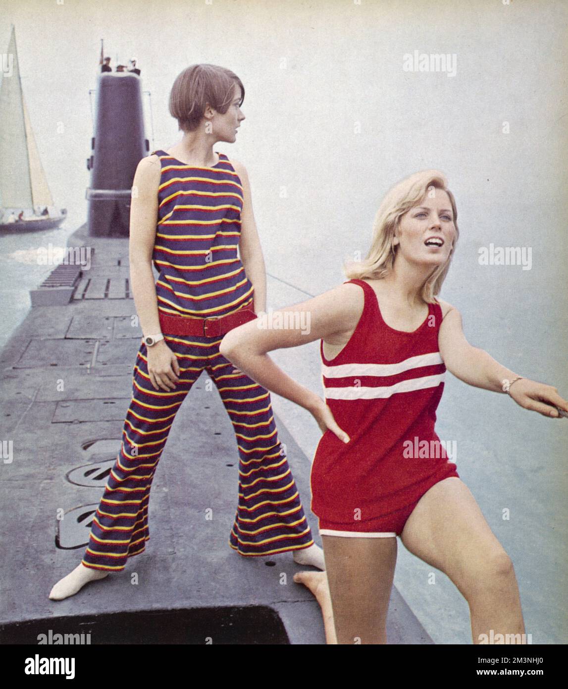 Some suggested high fashion outfits for Cowes during the sixties.  A dazzlingly striped cat suit in jersey by Jean Varon on the left and a pirate red towelling shorts with white piping and matching vest at Harrods.  The models pose on top of a Royal Navy submarine, the HMS Token outside of Gosport.       Date: 1966 Stock Photo