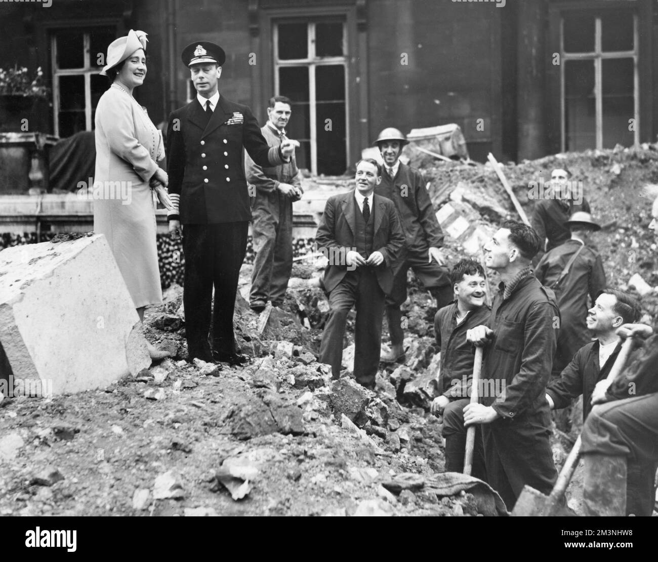 King George VI and Queen Elizabeth pictured among the rubble at Buckingham Palace following German air raids during the Blitz, September 1940.  The Palace suffered bomb damage on 8 September and on the morning of the 13th, the King and Queen were in residence when a bomb was dropped into the Quadrangle.  They escaped unhurt but one workman was killed.     Date: 1940 Stock Photo