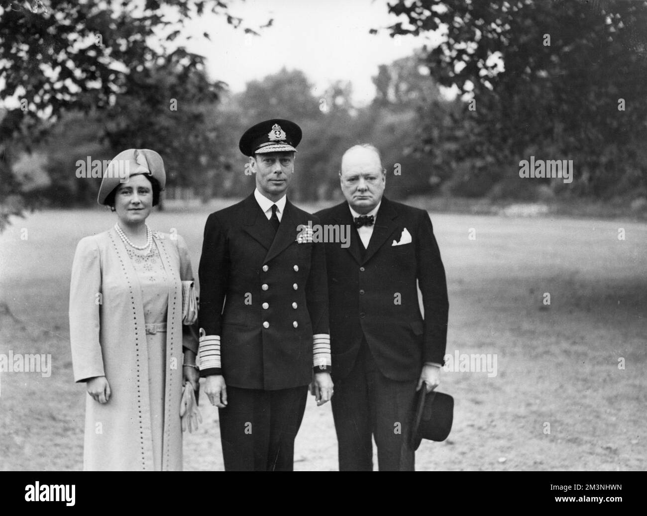 Wartime British Prime Minister, Winston Churchill photographed with King George VI and Queen Elizabeth at Buckingham Palace in September 1940 after the Palace had been damaged by German bombs during the Blitz.     Date: 1940 Stock Photo