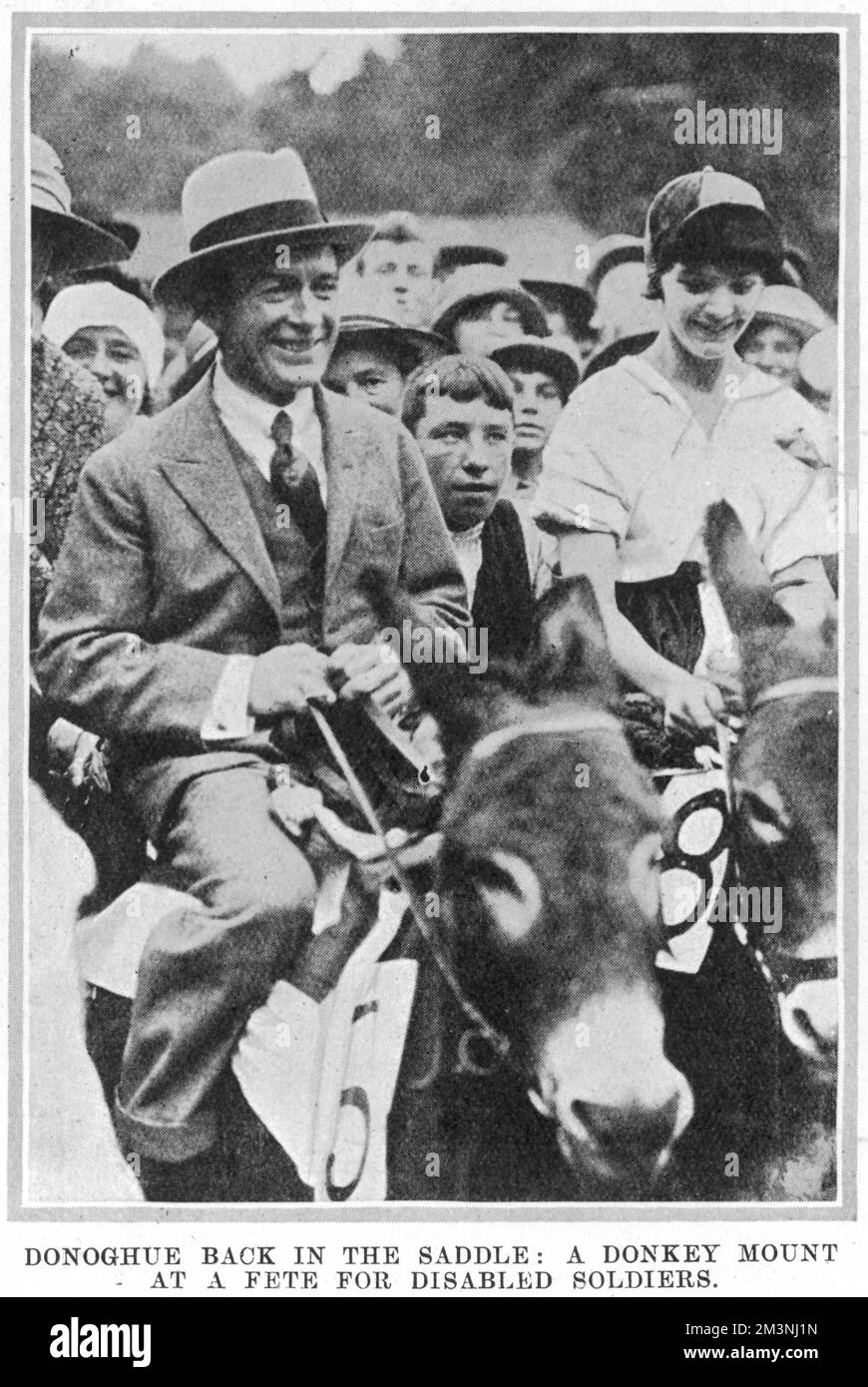 Steve Donoghue (1884 - 1945), English flat race jockey, winner of the Epsom Derby on six occasions pictured riding a donkey at a fete for disabled soldiers at Gifford House, Roehampton.  Donoghue had suffered a nasty fall from his horse at the Grand Prix de Paris earlier that year and had a broken arm but was well on the way to recovery by the time this picture was taken.     Date: 1925 Stock Photo