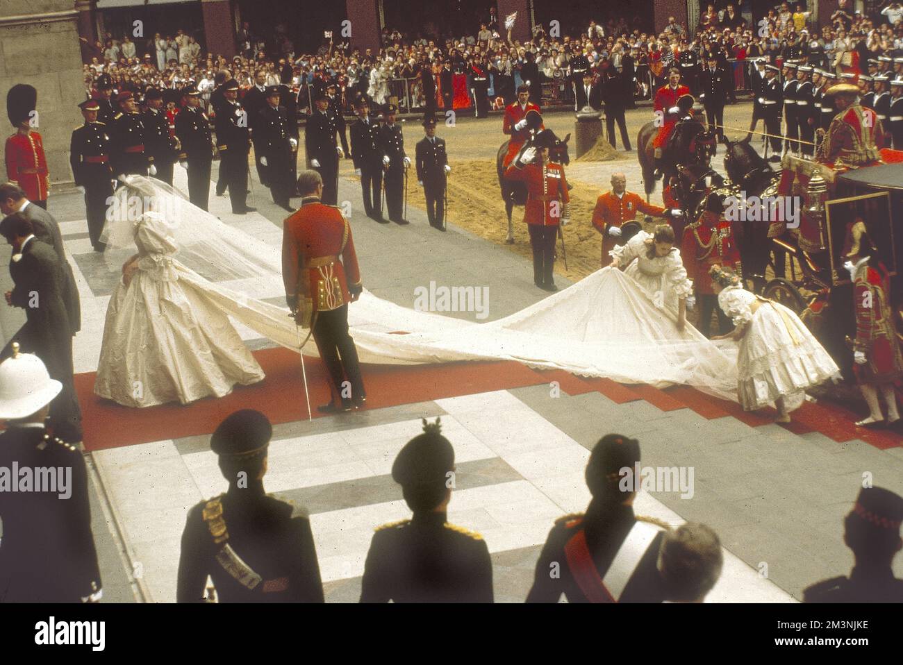 Lady Diana Spencer arrives at St Paul's Cathedral for her marriage to Prince Charles on 29 July 1981.  As she proceeds up the red carpeted steps, her bridesmaids arrange the train of her taffeta, designed by David and Elizabeth Emanuel.     Date: 1981 Stock Photo