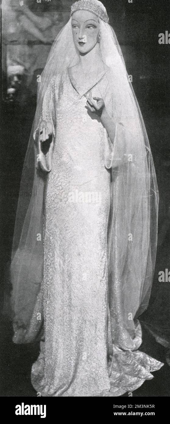 The silver flowered brocade gown worn by Princess Marina of Greece on her marriage to Prince George, Duke of Kent on 29 November 1934 at Westminster Abbey.  The dress, designed by Captain Edward Molyneux, a favourite designer of the Duchess, was exhibited at St. James's Palace in the three rooms where the extensive Royal Wedding presents were also on view.     Date: 1934 Stock Photo
