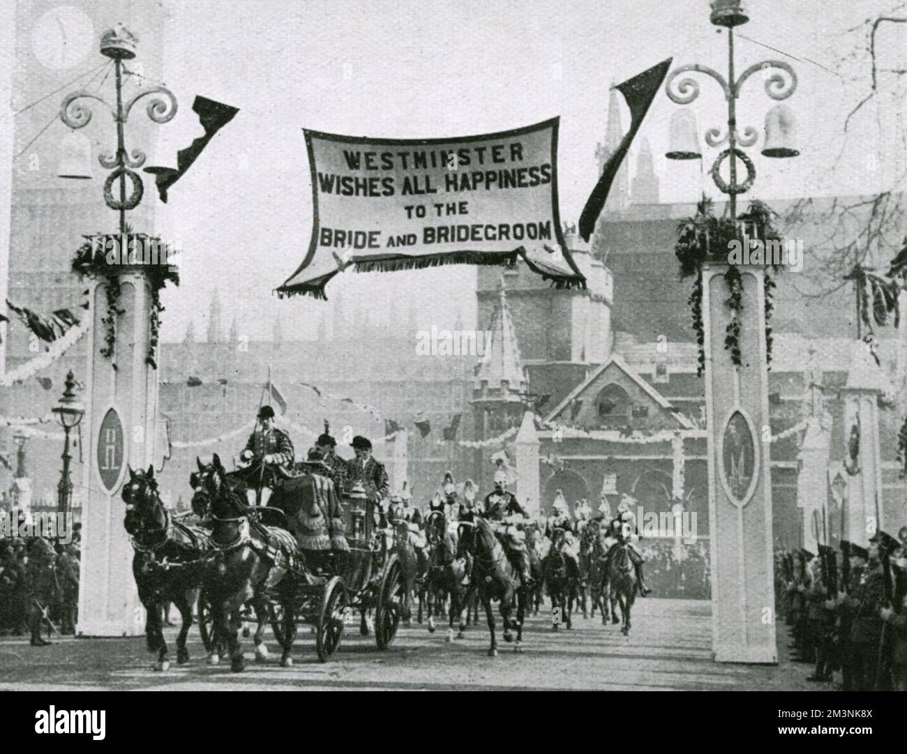 Wedding of Princess Mary, only daughter of King George V and Queen Mary, later Princess Royal and Countess of Harewood, to Henry, Viscount Lascelles, later 6th Earl of Harewood, on 28th February 1922. They were married at Westminster Abbey, and the route through Westminster was decorated. Here their carriage passes under a huge banner declaring 'Westminster wishes all happiness to the bride and bridegroom'.     Date: 28th February 1922 Stock Photo