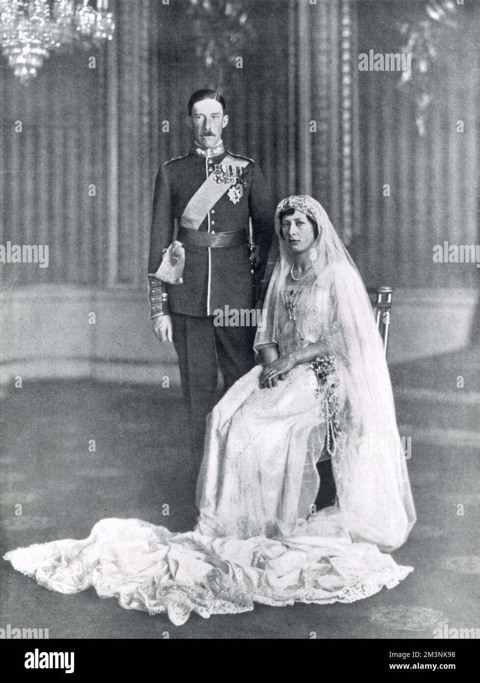 Princess Mary, daughter of King George V and Queen Mary, later the Princess Royal and Countess of Harewood, photographed with Viscount Lascelles, later the 6th Earl of Harewood, at Buckingham Palace immediately after their wedding on 28th February 1922. Lord Lascelles is wearing the ribbon of the Order of the Garter over his Guards uniform.     Date: 1922 Stock Photo