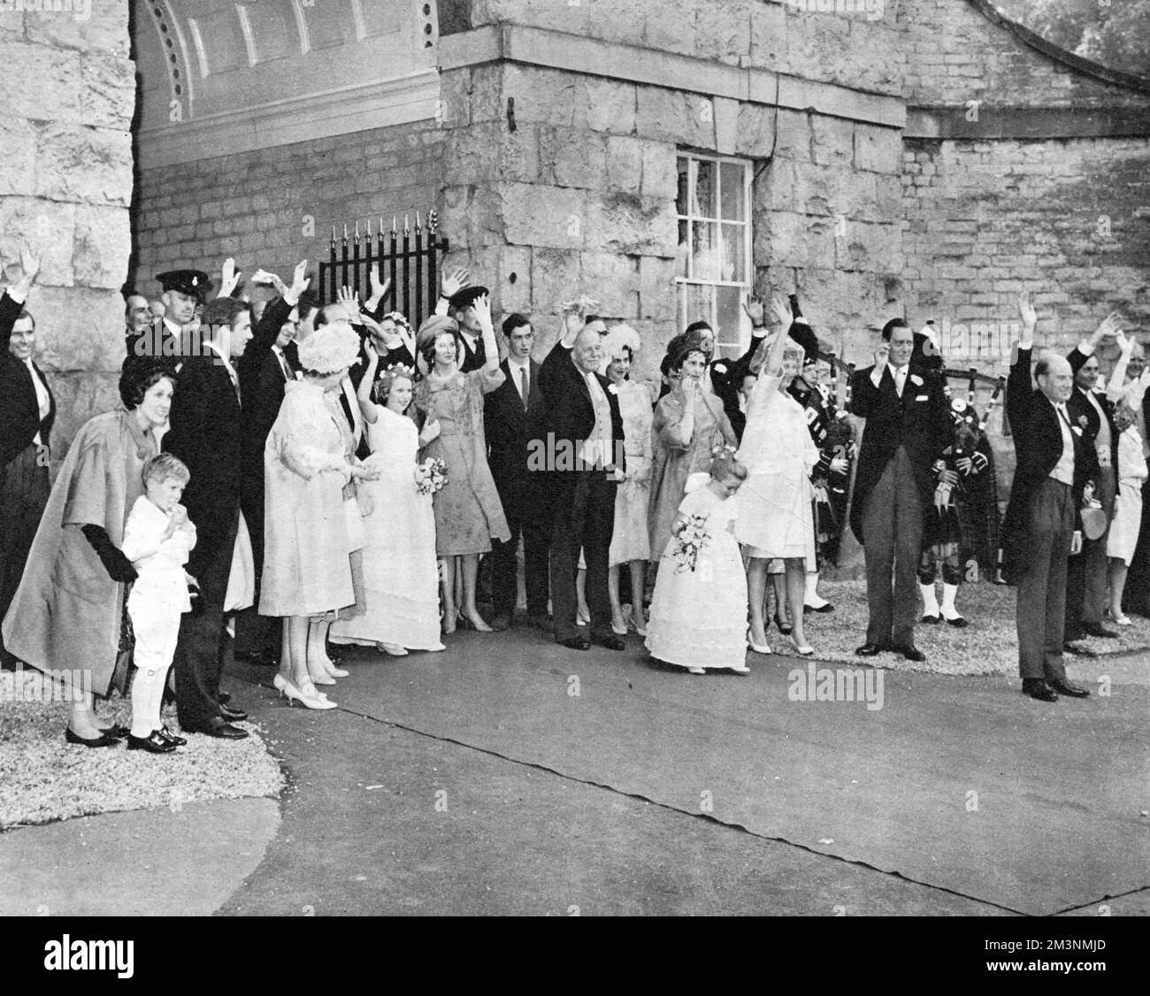 Wedding guests wave farewell to the departing newly married Duke and Duchess of Kent (formerly Miss Katherine Worsley) as they leave Hovingham Hall, the bride's family home for their honeymoon following their wedding at York Minster on 8 June 1961.  In the centre of picture can be seen the groom's sister, Princess Alexandra of Kent and Princess Anne (Princess Royal) who was one of the couple's bridesmaids.     Date: 1961 Stock Photo