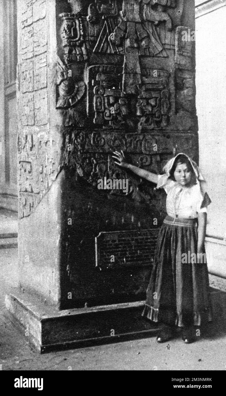 Believed to be the first of a dying race of Maya indians who has ever visited England: Emilia Vasquez standing by an ancient Maya monolith in the British Museum, where she was introduced to a lecture audience by explorer Mr. F.A Mitchell Hedges on 10th January 1926. Mitchell Hedges was lecturing on the discovery(in which he took a leading role) of the buried Maya city of Labaatun in British Honduras(today Belize). The girl was from the Maya Ketchi tribe of Central American Indians, whose people, as the Illustrated London News romantically put it,  'have dwindled to scanty remnant in the wilds Stock Photo