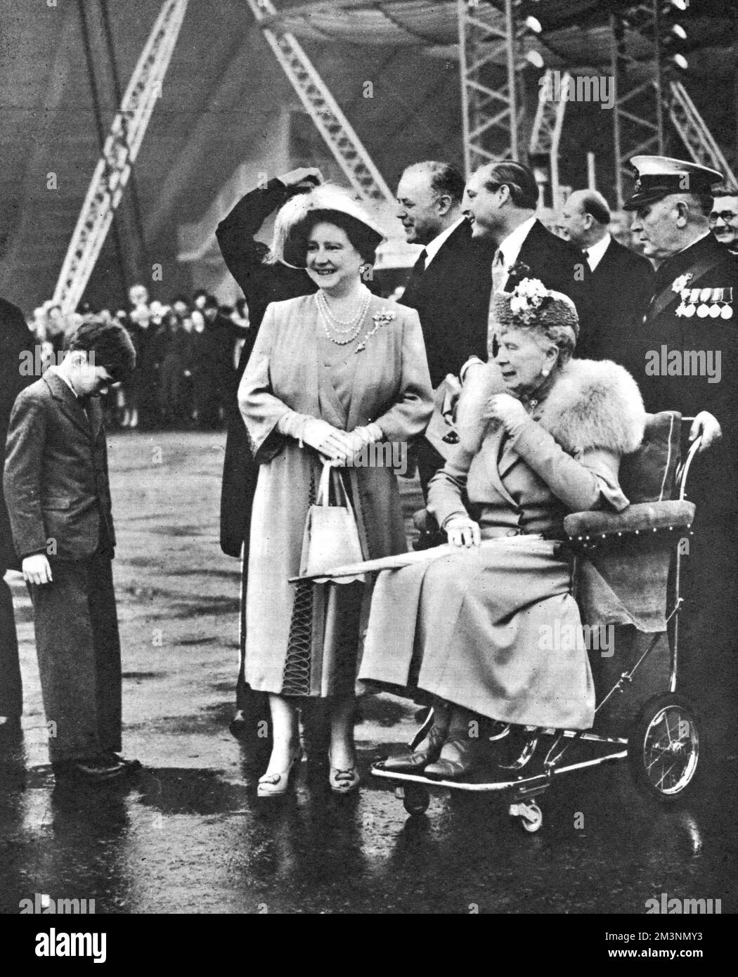 Scene at a royal visit to the Festival of Britain site on the South Bank, London.  Here Queen Elizabeth and Queen Mary (in a wheelchair) can be seen with the young Prince William of Gloucester on the left, and the Duke of Gloucester in the background.      Date: 4 May 1951 Stock Photo