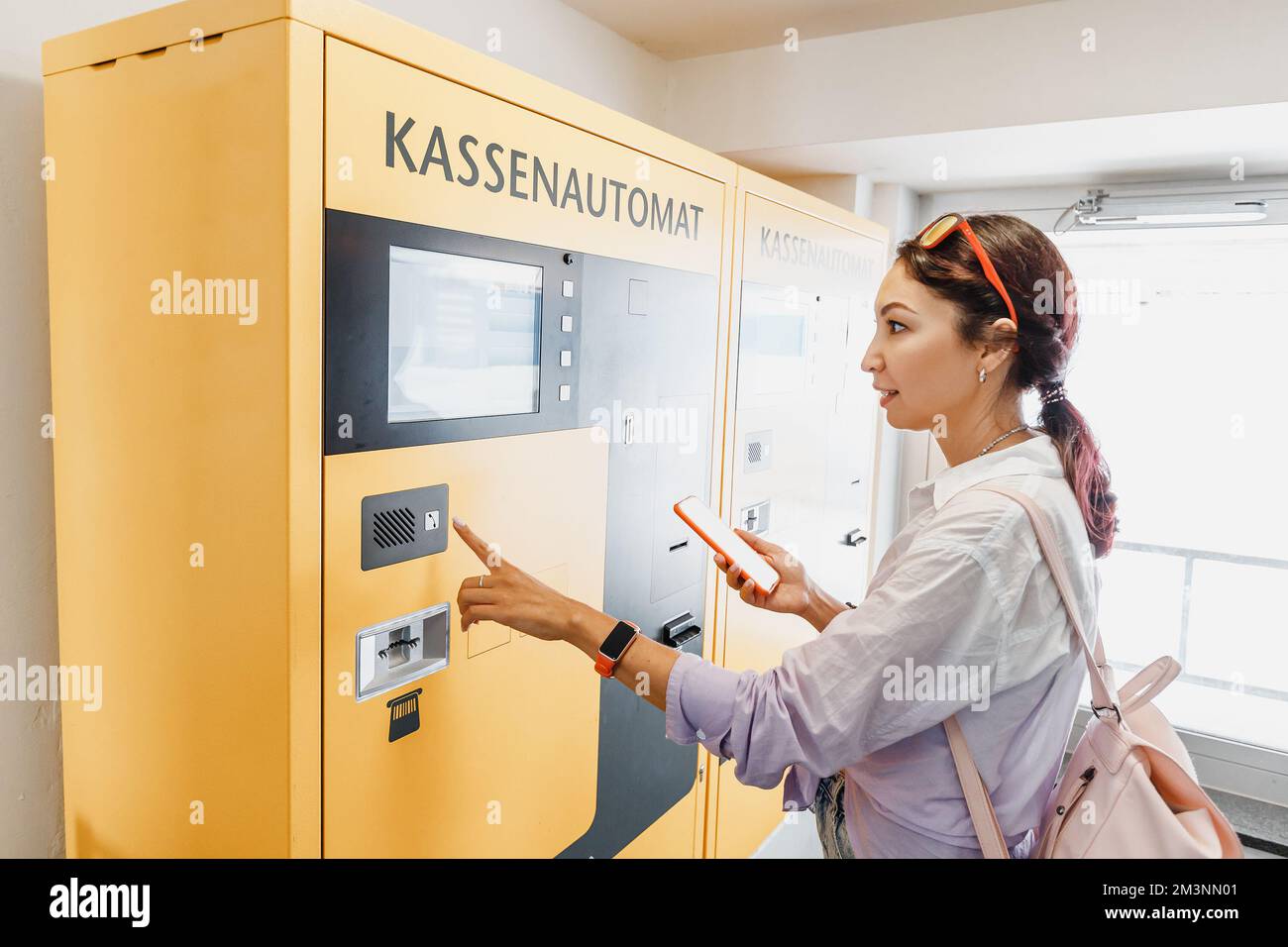 The girl pays for parking or buys a ticket for public transport in an ...