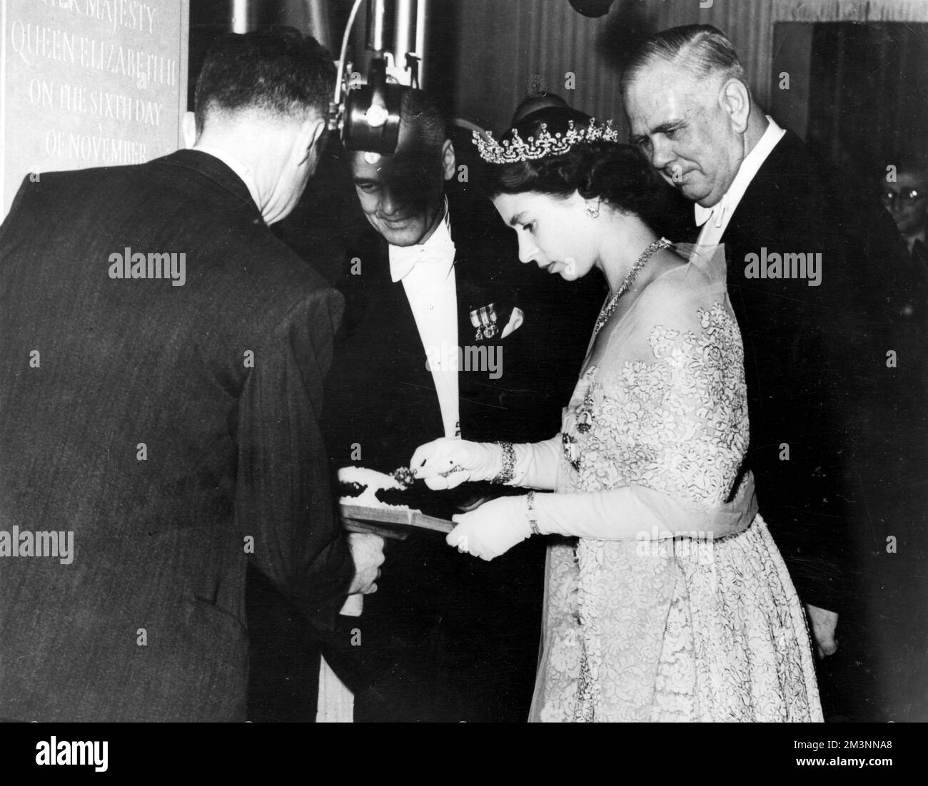 Queen Elizabeth II visits Lloyd's to lay the foundations tone of their new building in Lime Street. This picture shows her Majesty taking a trowel full of mortar ready to lay the stone.     Date: 6th November 1952. Stock Photo