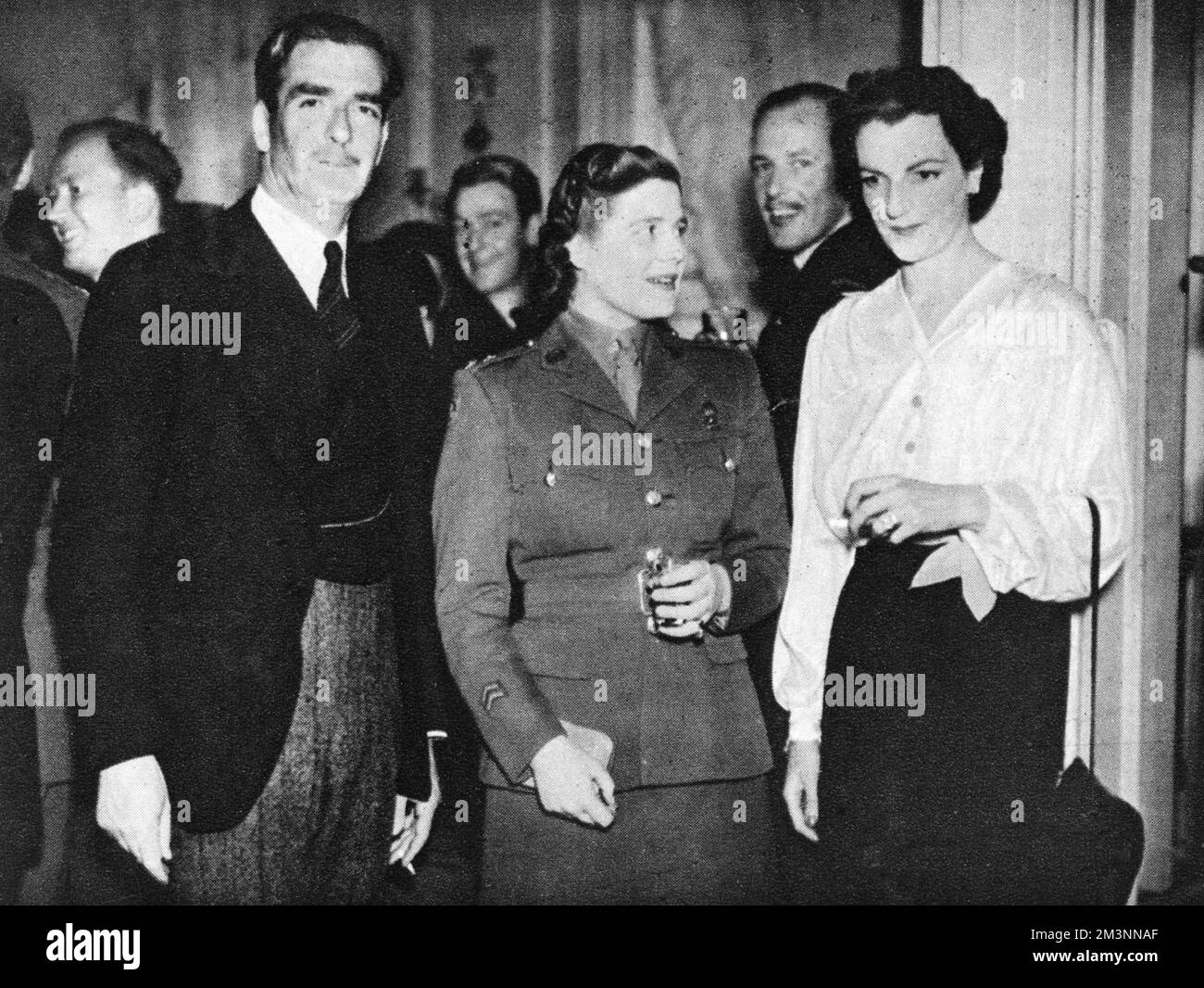 Anthony Eden looks in on the anniversary party of the All-Services Club, of which his wife is the president. Subaltern Mary Churchill, youngest daughter of Winston Churchill, is pictured here at the party, which she attended in her A.T.S uniform.     Date: 1944 Stock Photo