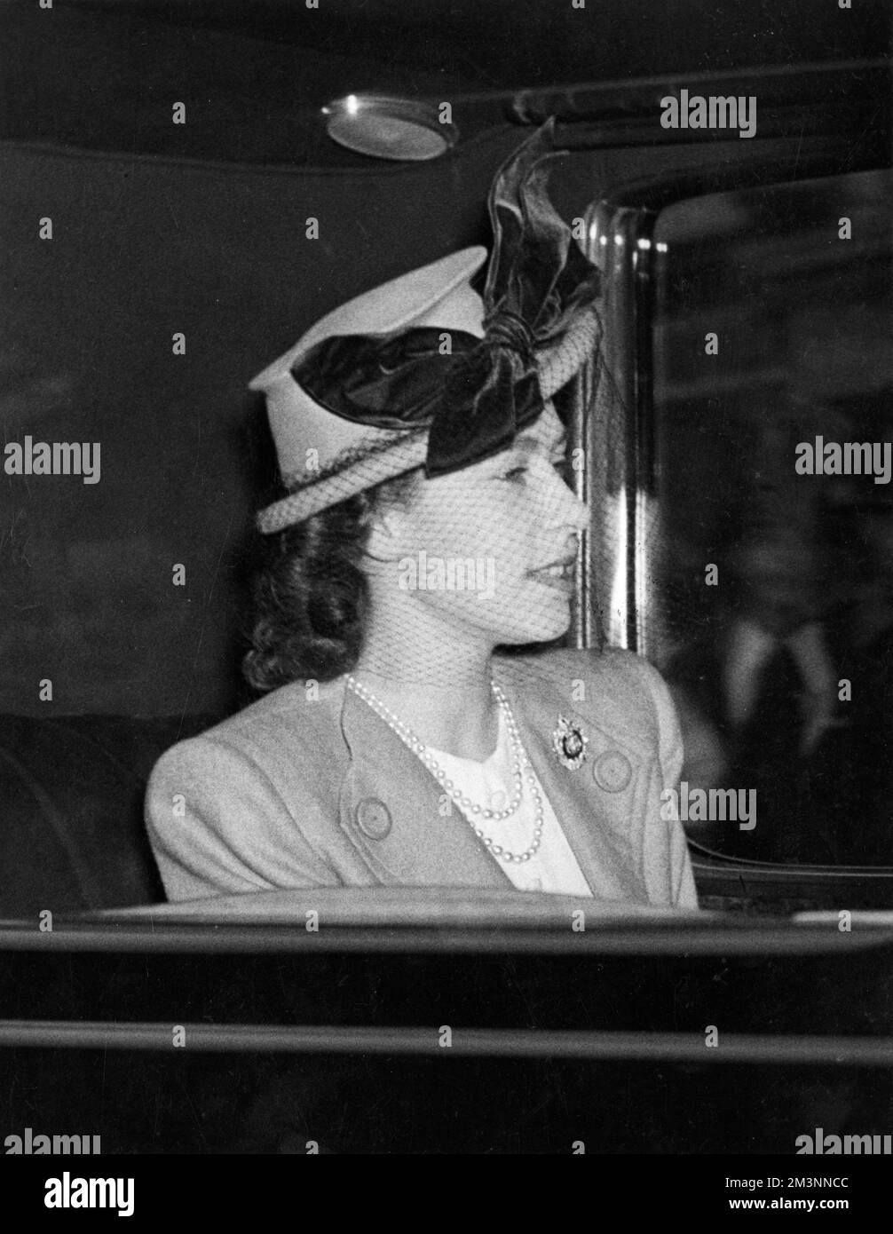 Princess Elizabeth (Queen Elizabeth II) wearing a striking hat as she drives away from Euston