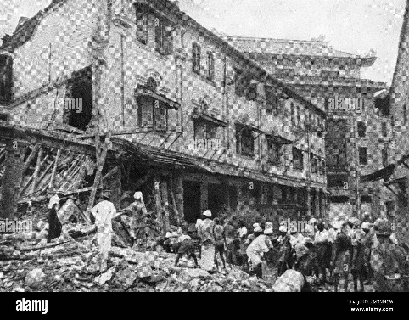 Following the capture of Malaya at the end of 1941, Japanese forces turned their attention to Singapore, a short distance away from the aerodromes they now held. Bombing raids on Singapore followed, and here the local population are seen clearing up debris following one such raid. Singapore was surrendered to the Japanese on 15 February 1942     Date: January 1942 Stock Photo