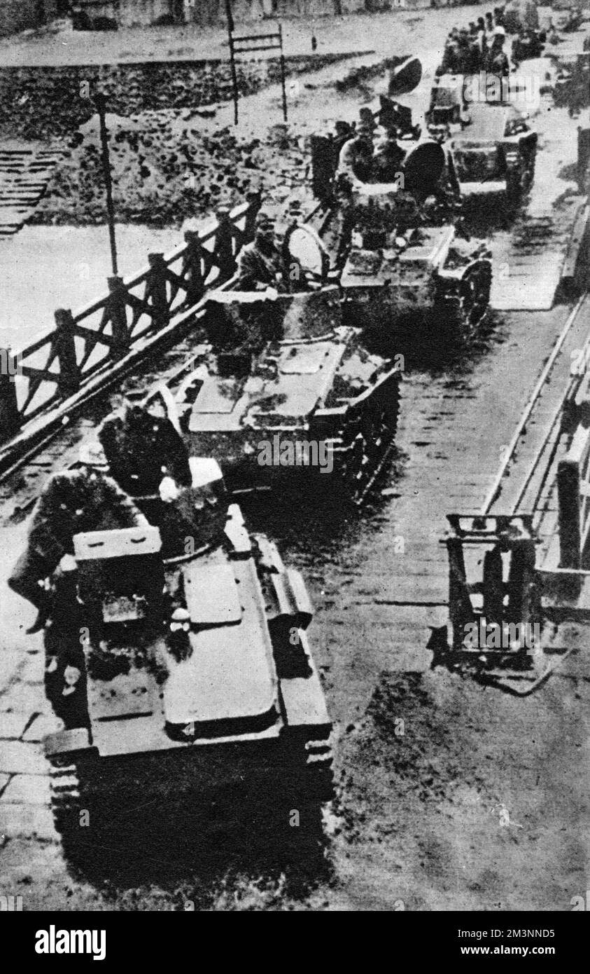 Japanese forces cross the causeway from Malaya to Singapore. Malaya had been taken from the retreating British and Commonwealth forces at the end of January 1942. This link with the mainland had been partly destroyed by the retreating forces but did not delay the Japanese invasion force for long. Singapore was surrendered on 15 February     Date: February 1942 Stock Photo