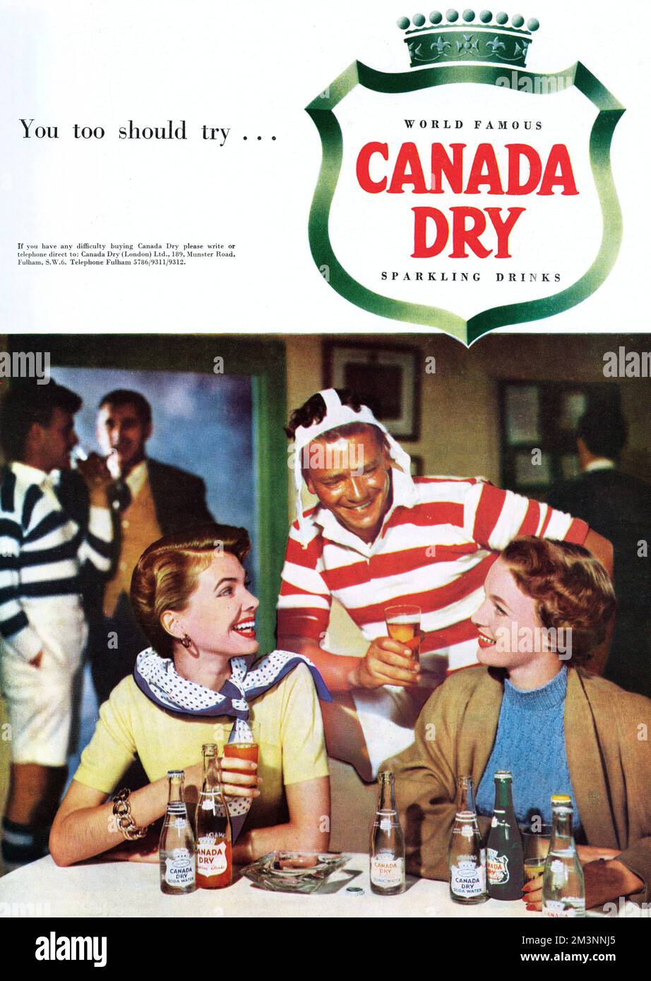 Mildly humorous advertisement for Canada Dry sparkling drinks featuring a photograph of two glamorous young women being flirted with by a sweaty rugby player after a game.     Date: 1953 Stock Photo
