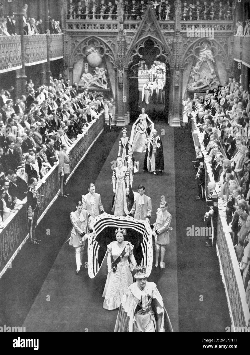 Queen Elizabeth, the Queen Mother passes along the nave of Westminster Abbey en route from the Annexe for the Coronation of her daughter, Queen Elizabeth II in June 1953.  She is followed by Princess Margaret and her retinue.     Date: 1953 Stock Photo