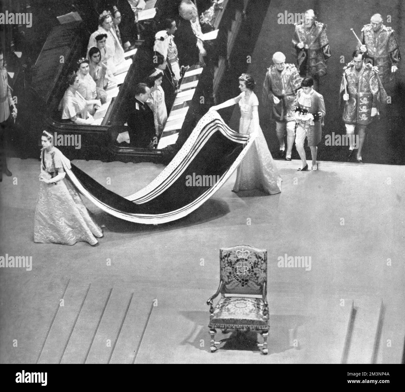 The sister of Queen Elizabeth II, Princess Margaret,  enters the Coronation Theatre in Westminster Abbey. Her train is carried by Miss Iris Peake, and she is followed by her page, Albemarle Bowes Lyon, who carries her coronet. Behind him are the Heralds of Richmond, York, Chester and Lancaster. In the foreground is the Throne.     Date: 1953 Stock Photo