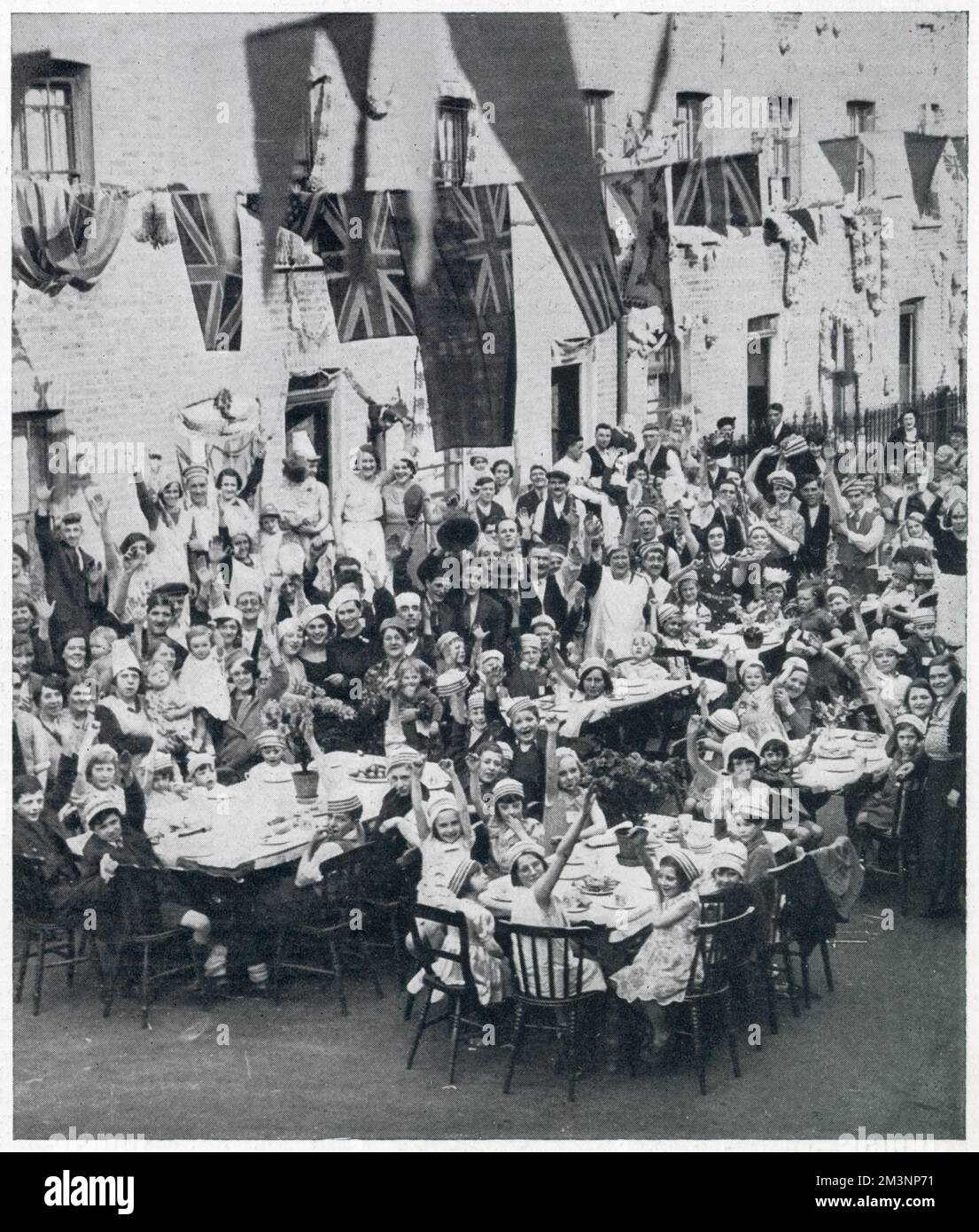 A street tea-party in Battersea, London, celebrating the Silver Jubilee of King George V. Stock Photo