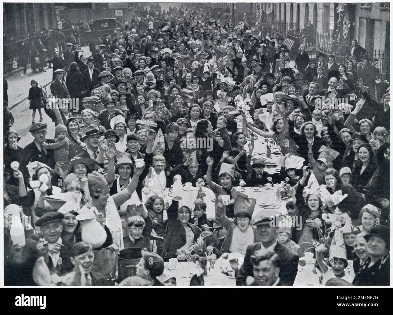 One of the many tea-parties held in the streets of London for poor children, in celebration of the Silver Jubilee of King George V. Stock Photo