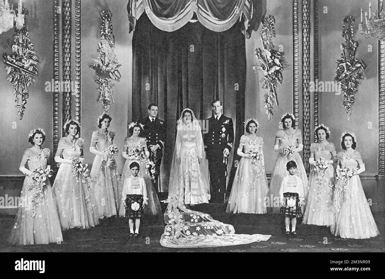 The wedding of the heir-presumptive to the British throne, Princess Elizabeth and Lieutenant Philip Mountbatten on 20 November 1947.A formal group photograph of the royal couple posed in the throne room at Buckingham Palace following the return of the royal couple from Westminster Abbey. From left to right is the Hon. Margaret Elphinstone, Lady Pamela Mountbatten, Lady Mary Cambridge, H.R.H Princess Alexandra of Kent, the Marquess of Milford Haven(the Groomsman), H.R.H Princess Margaret, Lady Caroline Montagu-Douglas Scott, Lady Elizabeth Lambart and Lady Diana Bowes-Lyon. The pages are H.R.H Stock Photo
