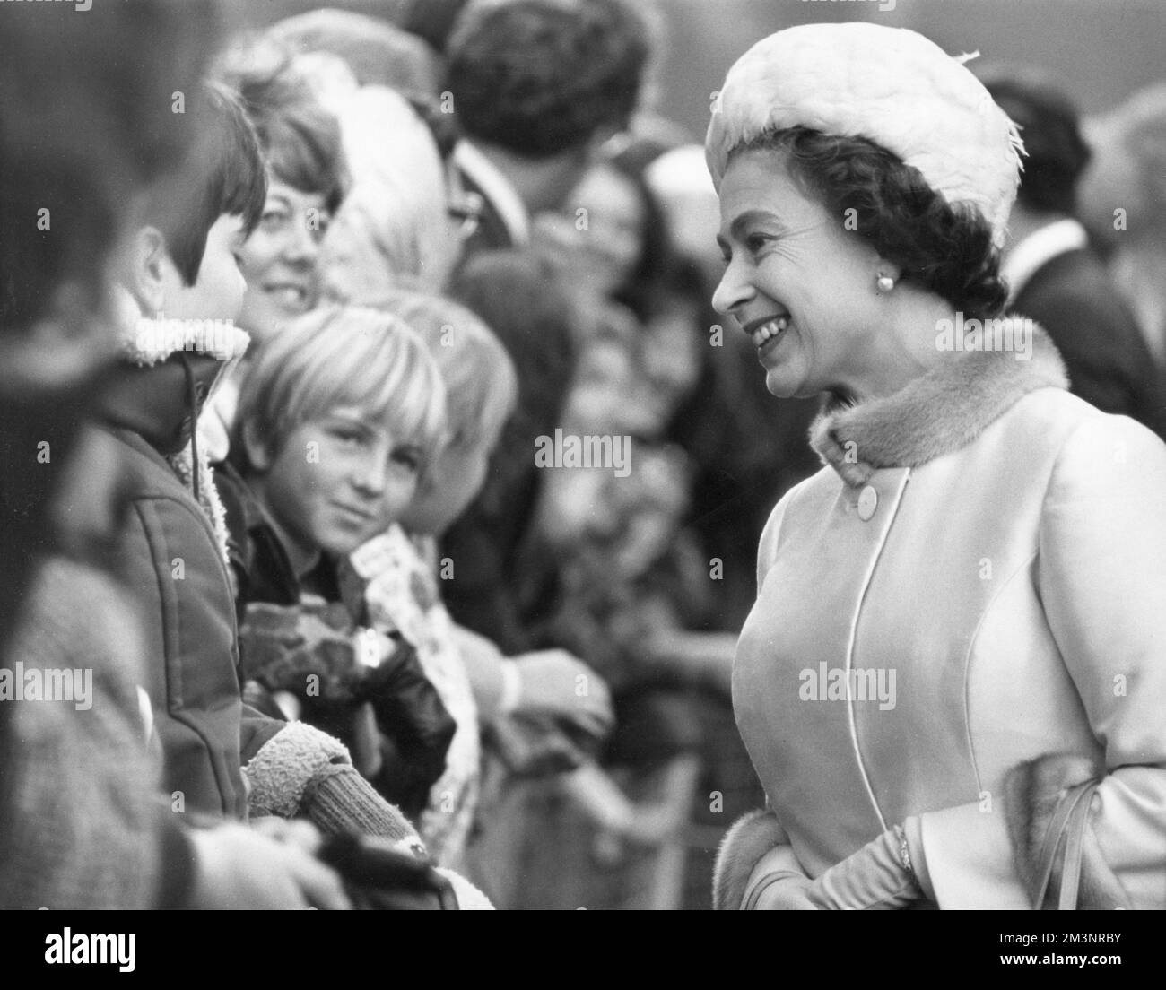 Queen Elizabeth II talks to children among the crowds during her walk ...