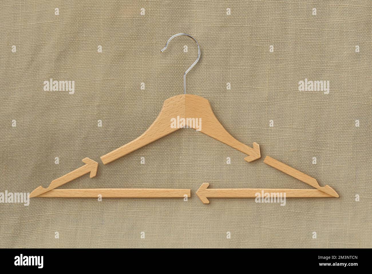 Wooden hanger with recycling arrows on fabric background Concept of