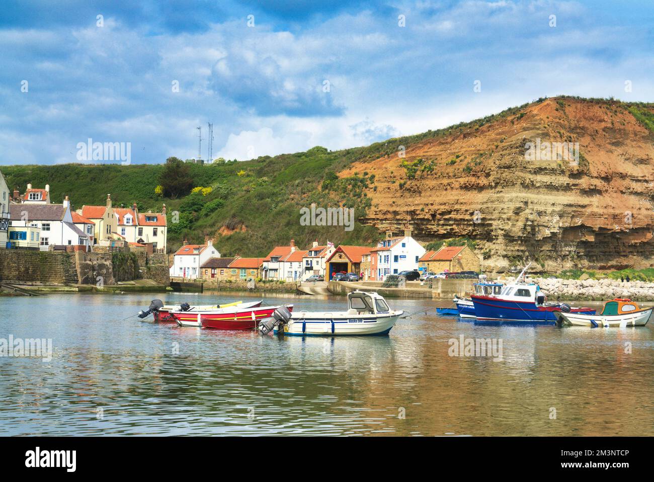 Staithes harbour, beach and cliffs from beach at high tide. North