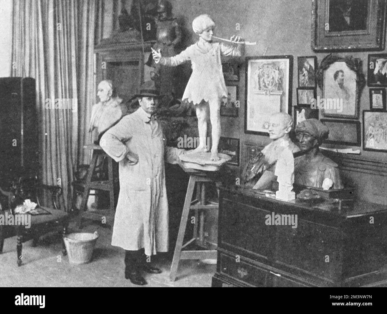 Sir George Frampton pictured in his studio with a sculpture of Peter Pan, the famous fictional creation of J. M. Barrie.  The sculpture was erected in Kensington Gardens on 1 May 1912.  There was no formal unveiling and the statue simply appeared, as if by magic, one morning.     Date: 1912 Stock Photo