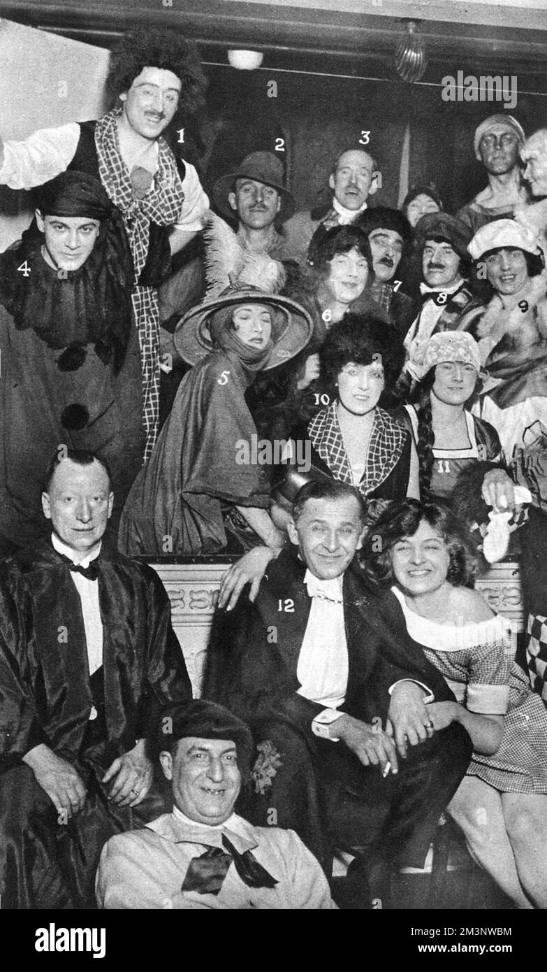 A group of revellers in fancy dress costume at the Annual Chelsea Arts Ball.  Numbered as 1.  Mr E. Sturt, 2. Captain A. Mills, 3. Major Blackwell, 4 Mr H.C.B. Whinney, 5 Lady Dorothy Mills, 6 Miss Helen McKie, 7 Mr Ernest Still, 8 Mr Howard Elcock, 9 Mrs Howard Elcock, 10 Mrs Ernest Still, 11 Miss D Grey and 12 Mr Melville Gideon.  Both Howard Elcock and Helen McKie were well-known illustrators of the time, working particularly for The Bystander magazine.       Date: 1924 Stock Photo