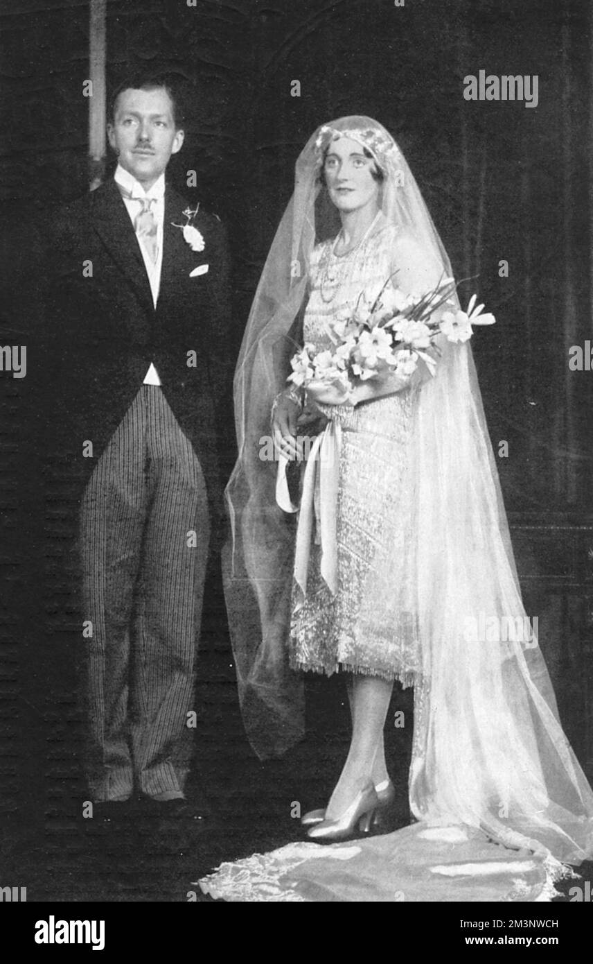The wedding of World War I flying ace, Captain Alec Cunningham-Reid (1895 - 1977) to Hon. Ruth Mary Clarisse Ashley, daughter of multi-millionaire, Lt-Col Wilfred Ashley (1st Baron Mount Temple) and sister of Edwina, Countess Mountbatten. The couple were described as 'England's wealthiest girl and handsomest man'. When the couple divorced in 1940, Alec sued his ex-wife for half her fortune. Great wedding dress!     Date: 1927 Stock Photo