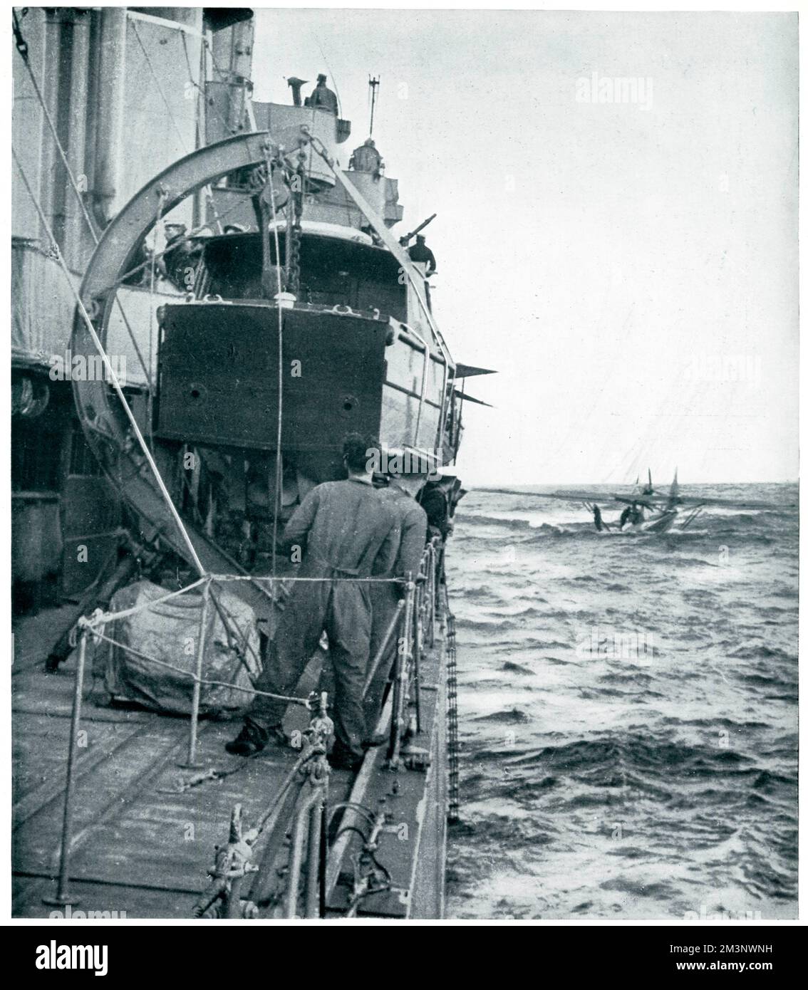 A scene out in the North Sea showing the crew of a German flying boat, which had participated in an air attack upon ships of the British fleet waiting to be rescued by a British destroyer having been brought down after an action that lasted five hours.  The bomber came down in the sea, the crew too k to their collapsible rubber boat, and were then rescued.  The German plane was then sunk by gunfire.       Date: 1939 Stock Photo