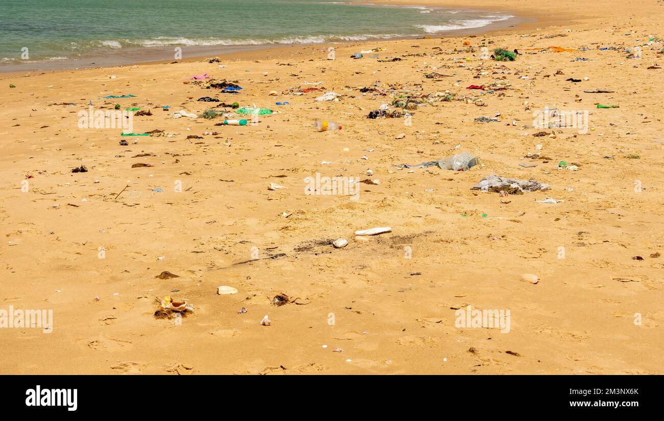 WARANG, MBOUR, SENEGAL - Circa JANUARY 20222. Beach sand of atlantic ocean with so many garbage plastic pollution in Senegal Africa. No place for tour Stock Photo