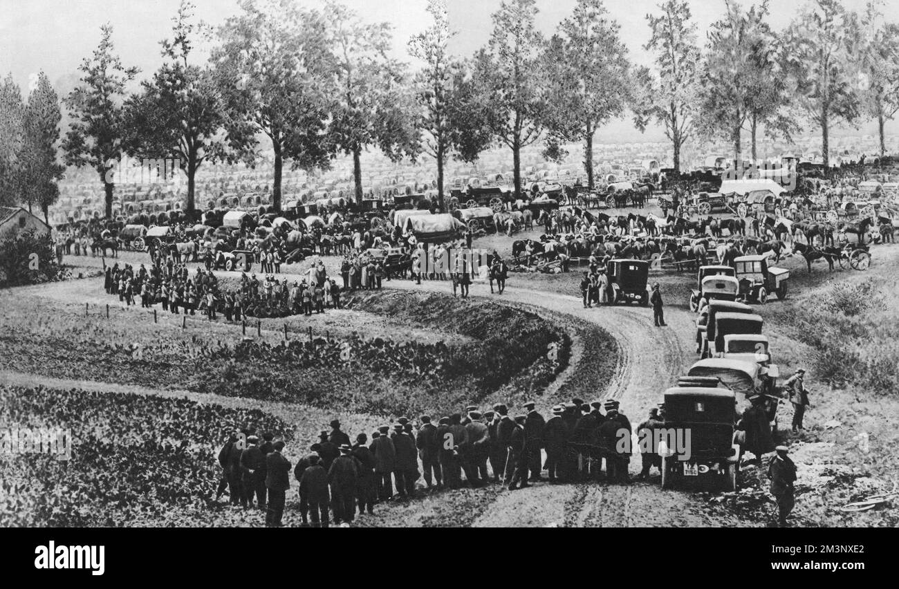 A large German military camp near Li&#x99e5; in Belgium, following the struggle for the town of Vis&#x9824;uring the German advance. To the centre left may be seen some Belgian prisoners with behind them and beyond the trees the mass of German carriages and horses. In the foreground are a few curious Belgian spectators.  August 1914 Stock Photo