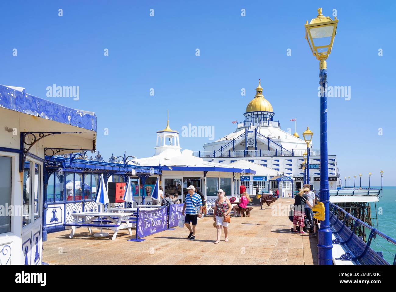 Eastbourne East Sussex People walking on Eastbourne Pier past the tearooms on Eastbourne Pier Eastbourne East Sussex England UK GB Europe Stock Photo