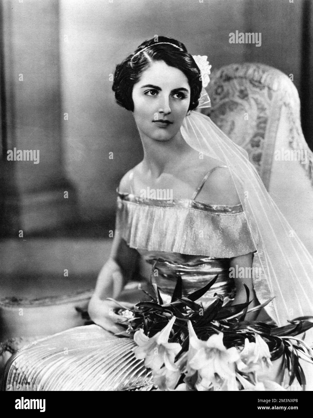 Lady Gloria Vaughan, daughter of the Earl and Countess of Lisburne, 'one of the most important debutantes of the year' according to The Sketch magazine, pictured in the dress she wore to be presented at the first court of the Season on 15 May 1934.     Date: 1934 Stock Photo