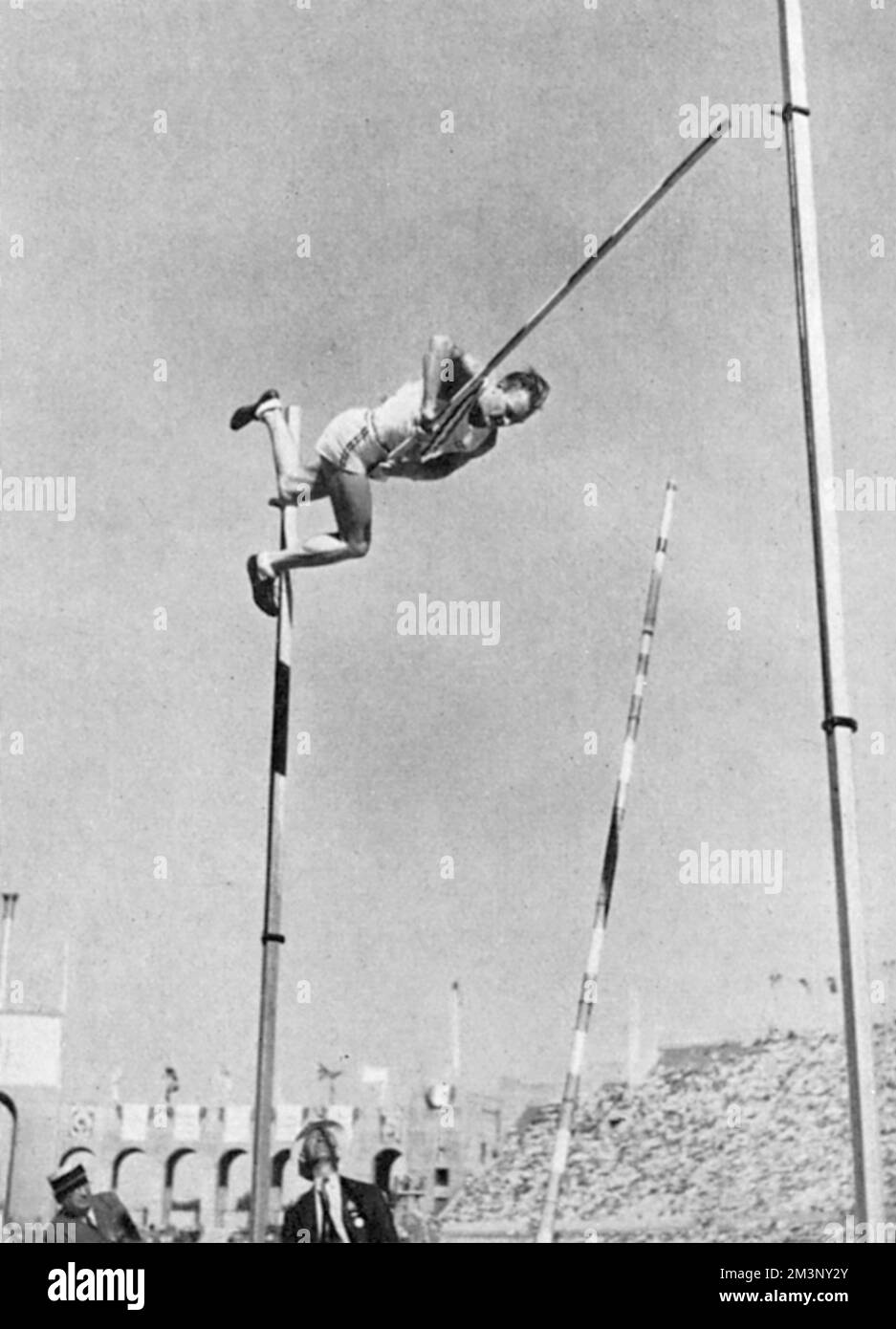 A falling American polevaulter grips the cross bar as he makes his descent at the 1932 Los
