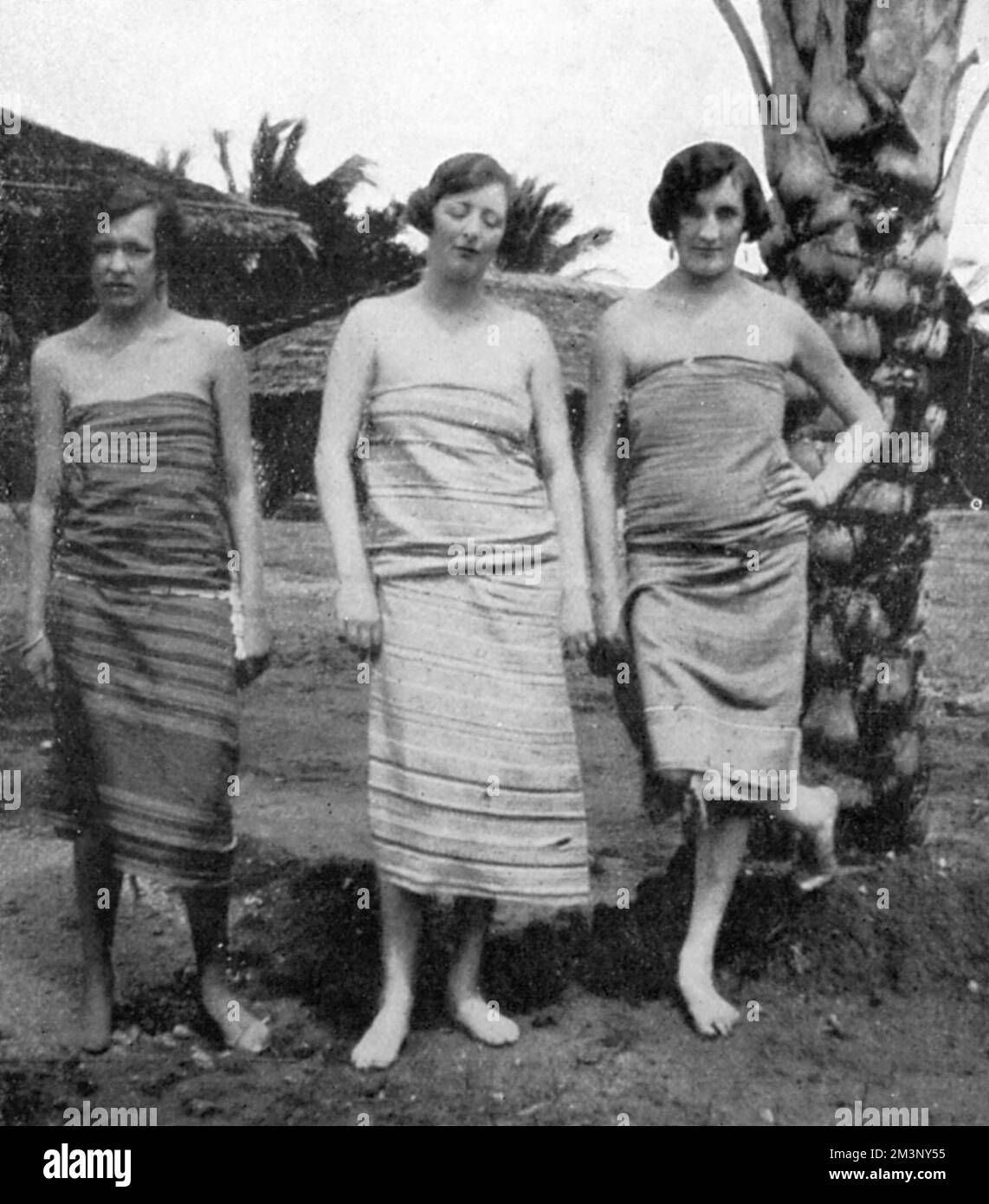 Lady Idina Hay (nee Sackville), pictured in a sarong or kanga with two friends in Kenya during the 1920s, while she was married to Josslyn Hay, Earl of Erroll.  On the left is the Countess N. de Graevenitz and on the right, Mrs. M. Roberts, both similarly attired.  Five-times married Idina would gain notoriety as part of the Happy Valley Set when she moved to Kenya in 1924 with her third husband, Josslyn Hay, Earl of Errol. With her serial marriages and reputation for debauched decadence, she inspired the character of 'The Bolter' in Nancy Mitford's novels, The Pursuit of Love and Love in a Co Stock Photo