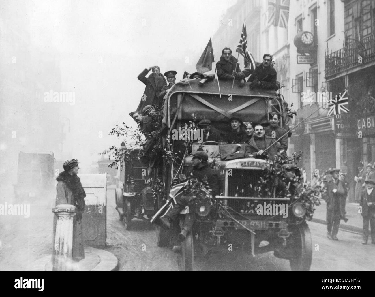 A Leyland lorry in London filled with men celebrating Armistice Day on 11th November 1918. Some wear military uniform, others civilian clothes.  11th November 1918 Stock Photo