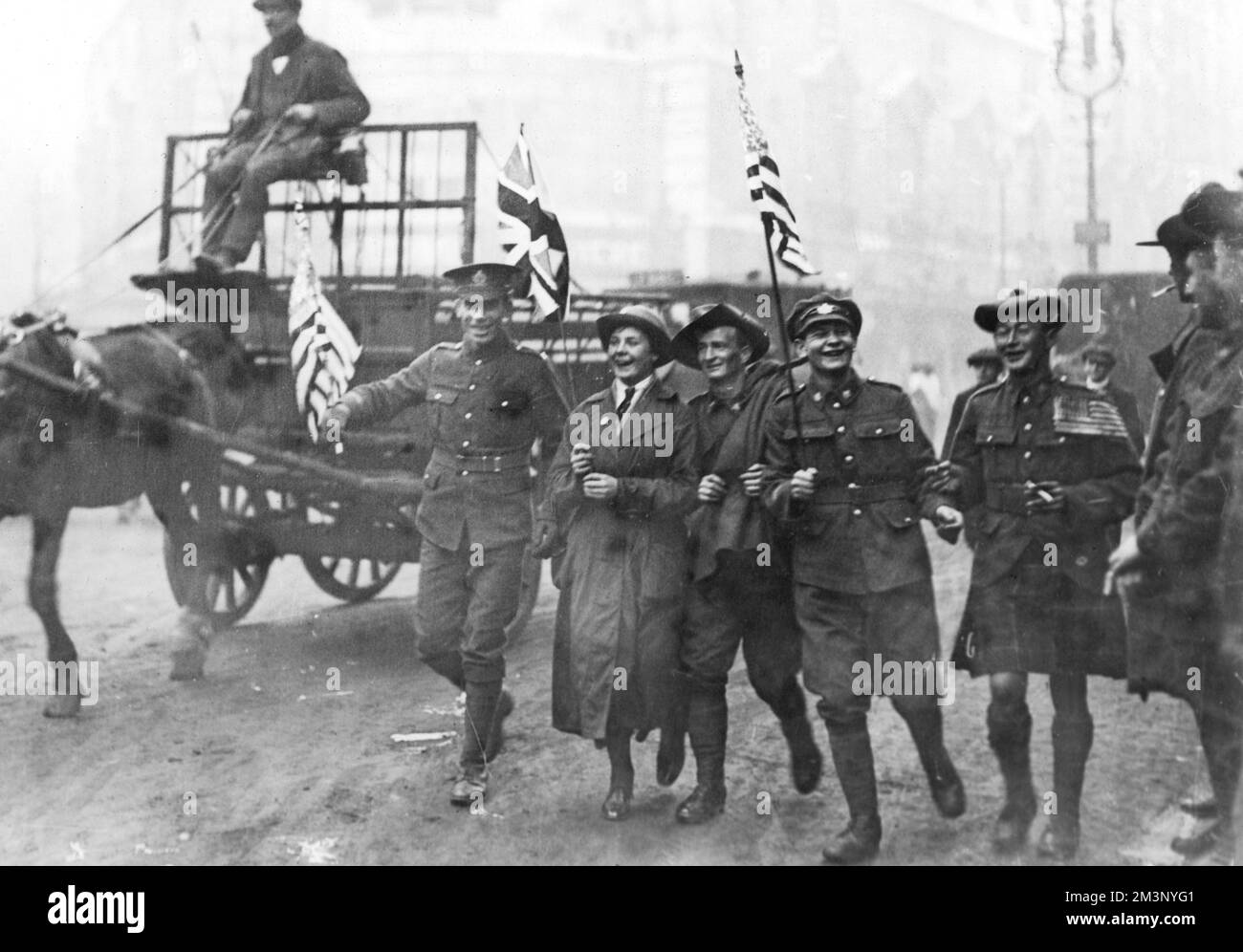 Armistice Day scene in London at the end of World War One: soldiers with British Union Jack and American Stars and Stripes flags.  11th November 1918 Stock Photo