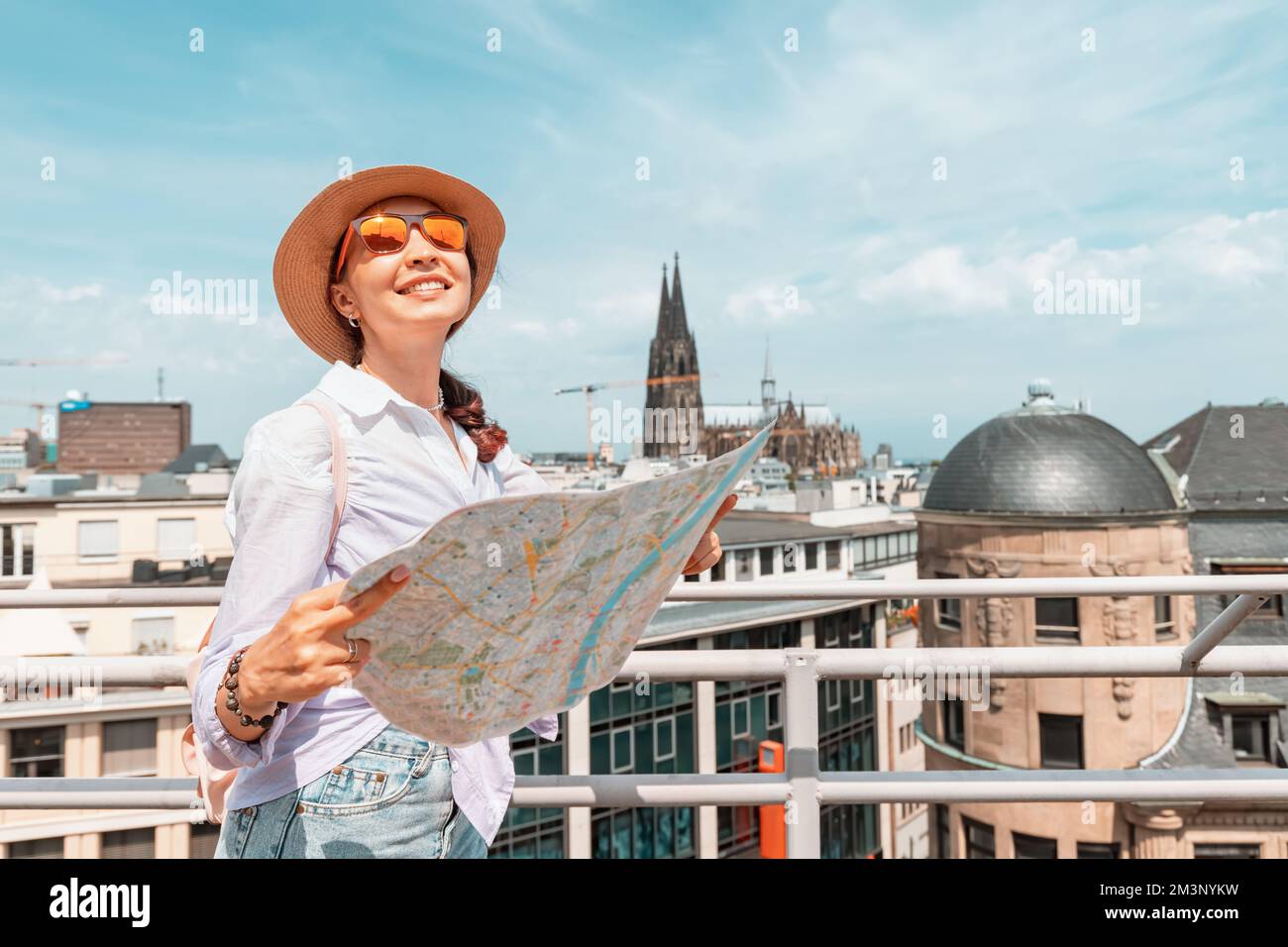 Navigating path destination hi res - Tourist Girl With Maps Navigating For Sights And Landmarks And Geolocating On The Streets Of An Old European City Cologne Cathedral In The Backgroun 2M3NYKW