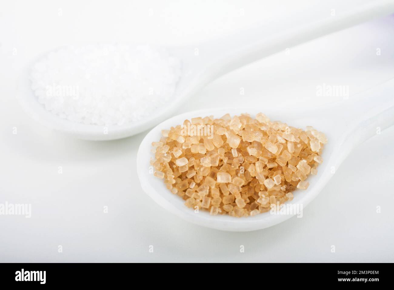White and brown sugar in spoon isolated on white background Stock Photo