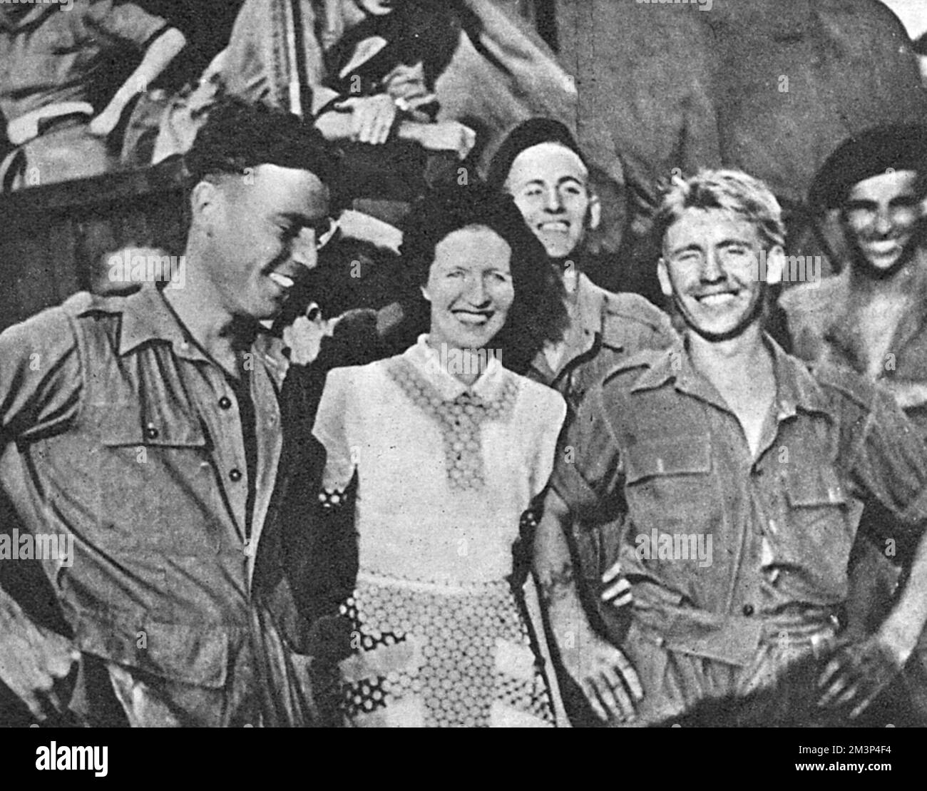 Following four months confinement, some of the newly released paratroopers, their sentences quashed, are seen here with the wife of a newspaper correspondent.  In May 1946, at the Muar Camp in Malaya, over 250 privates refused to obey orders and were later charged with mutiny. Three were acquitted, eight sentenced to five years penal servitude and the rest two years imprisonment. When news reached the UK, two days after sentencing, the Judge Advocate-General quashed the sentences due to irregularities that made the trial unsatisfactory.     Date: 1946 Stock Photo