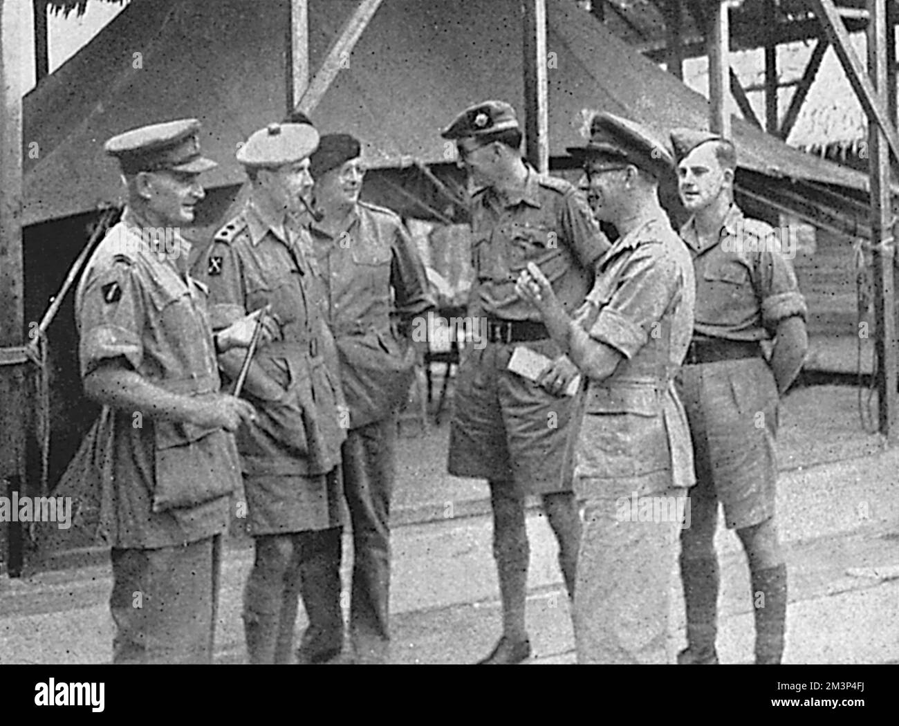 Presiding officer of the court martial, Brigadier M.V.Wright (left), commander of the 14th Indian Infantry Brigade, with members of the court awaiting the start of the day's proceedings. The Judge-Advocate, Major J.D.M.Smith, is wearing a black beret.  In May 1946, at the Muar Camp in Malaya, over 250 privates refused to obey orders and were later charged with mutiny. Three were acquitted, eight sentenced to five years penal servitude and the rest two years imprisonment. When news reached the UK, two days after sentencing, the Judge Advocate-General quashed the sentences due to irregularities Stock Photo