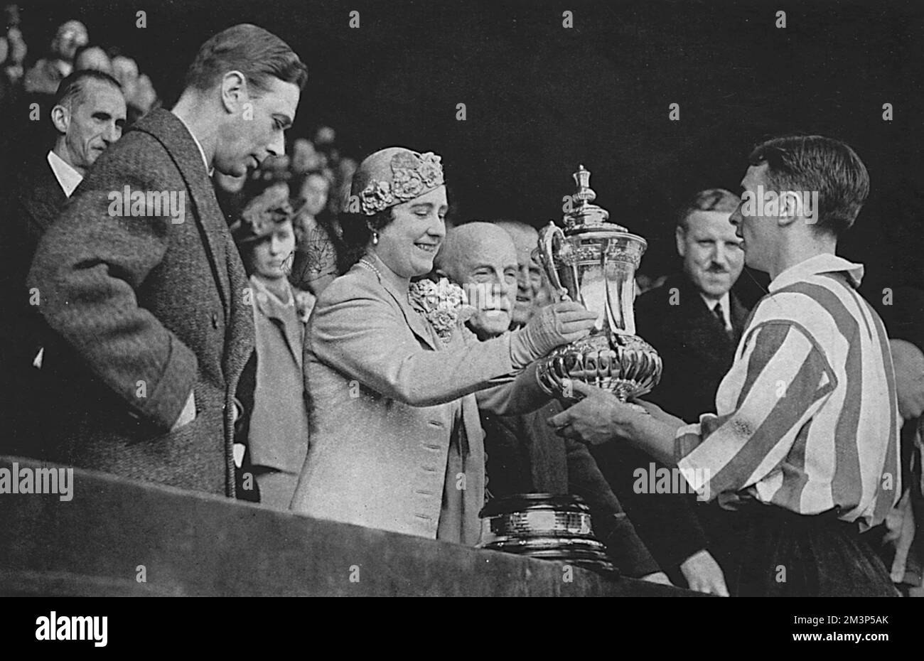 George VI and Queen Elizabeth present the FA Cup to Raich Carter, captain of the winning Sunderland team after the cup final at Wembley against Preston North End.  1937 Stock Photo