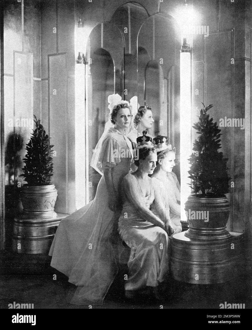 Examples of hair styles for the coming Coronation season on display at the Mayfair hotel organised by the Incorporated Guild of Hairdressers.  The coiffures in the foreground are suggested as teh most suitable for wearing with a peeress's coronet and those in the background suitable for debutantes.  Coronets were worn above light tiaras - quite a lot to fit on one's head.     Date: 1937 Stock Photo