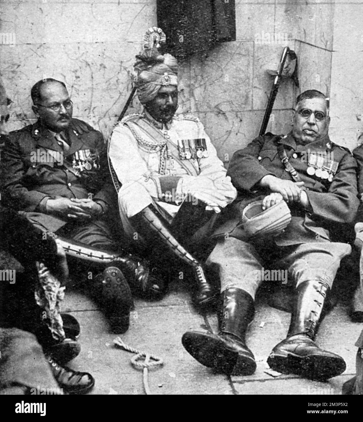 Indian officers resting at the foot of the Queen Victoria Memorial after playing their part in the Coronation procession of King George VI on 12 May 1937.     Date: 1937 Stock Photo