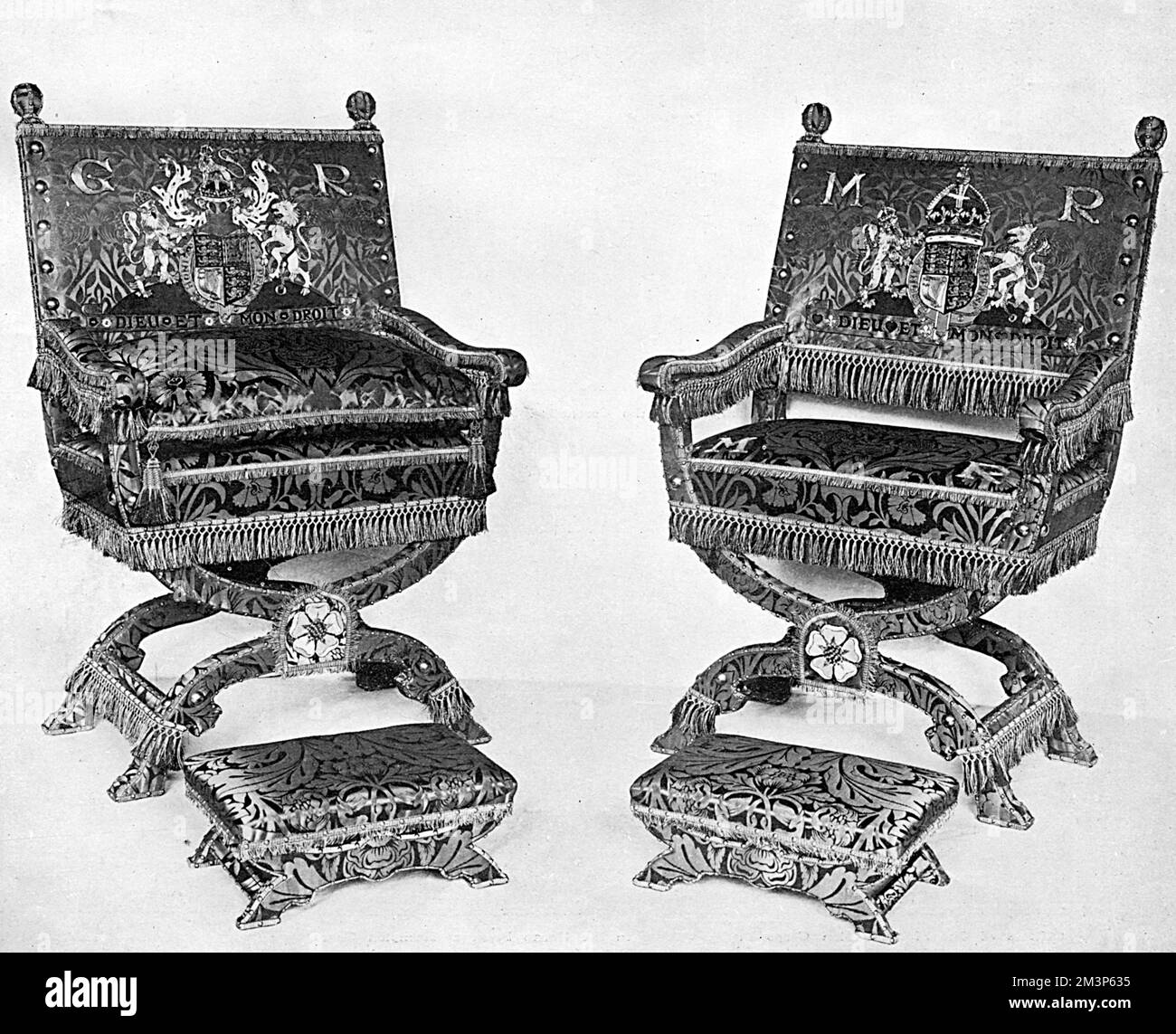 The thrones used for the enthronisation stage of the ceremony during the coronation of King George V in June 1911.  These would be used following the crowning of the King on St. Edward's Chair and differ for each coronation.  This pair were reproduced by Messrs Morris (William Morris) from Jacobean originals from Knole with an X-shaped back supports of beechwood and upholstery of crimson silk damask specially designed by William Morris some years before.  The silk was dyed with pure madder and woven on the Morris looms at Merton Abbey.     Date: 1911 Stock Photo