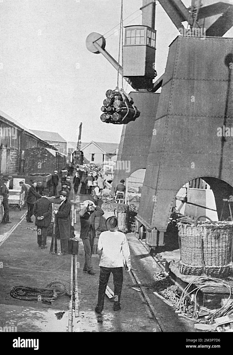 A dockyard scene during the First World War showing munitions being hoisted aboard a battleship.       Date: 1915 Stock Photo