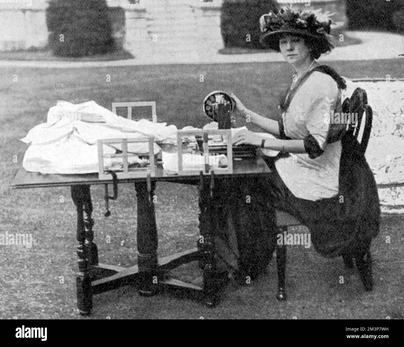The Duchess of Westminster busy with her sewing machine making hospital clothes for the wounded during the First World War.  The Tatler reports that the Duchess was equipping a field hospital (she would later open her hospital at the casino in Le Touquet) and superintending the preparation of Gifford House, Roehampton.  Constance Edwina Lewes, CBE (formerly Grosvenor, n&#x9960;Cornwallis-West; 1876 &#x2212; 21 January 1970), also known as Shelagh, was a British socialite and peeress.  She was the first wife of Hugh Grosvenor, 2nd Duke of Westminster (known as Bend'or), one of the richest men i Stock Photo