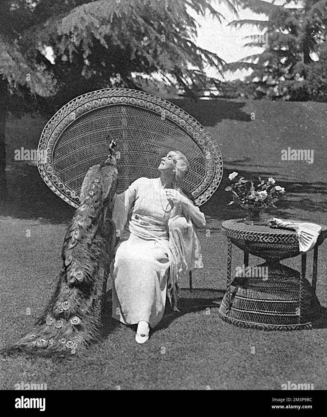 Ruth Saint Denis (1879 - 1968), modern dance pioneer, introducing eastern ideas into the art. She was the co-founder of the American Denishawn School of Dance and the teacher of several notable performers.  Pictured at home, in her garden in California with her pet peacock.       Date: 1917 Stock Photo